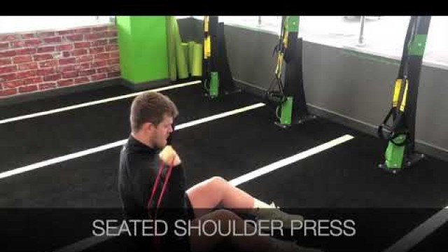 'Seated shoulder press with a resistance band demo at Energie Fitness Cardiff St Mellons gym'